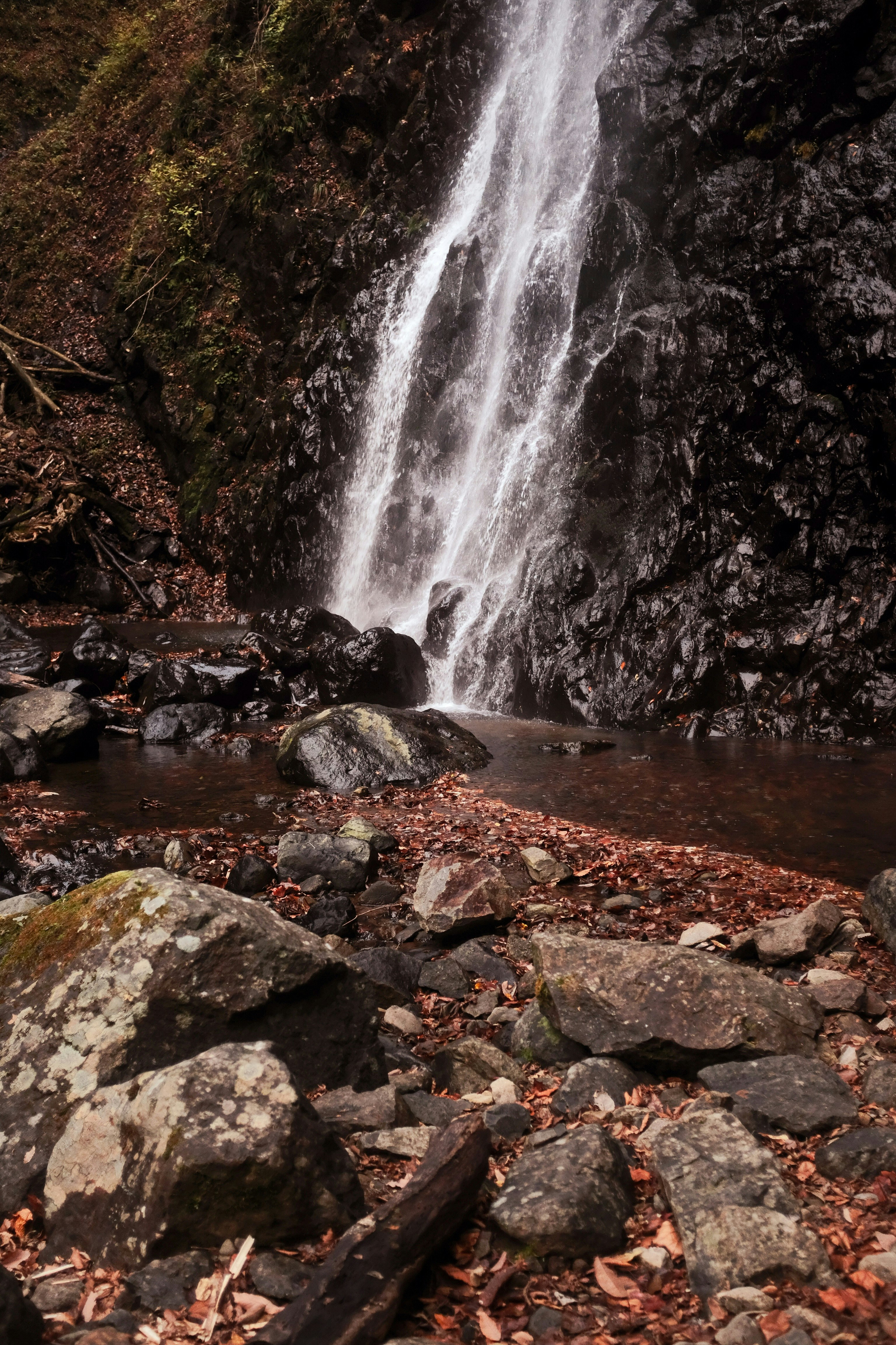 water falls on rocky shore during daytime